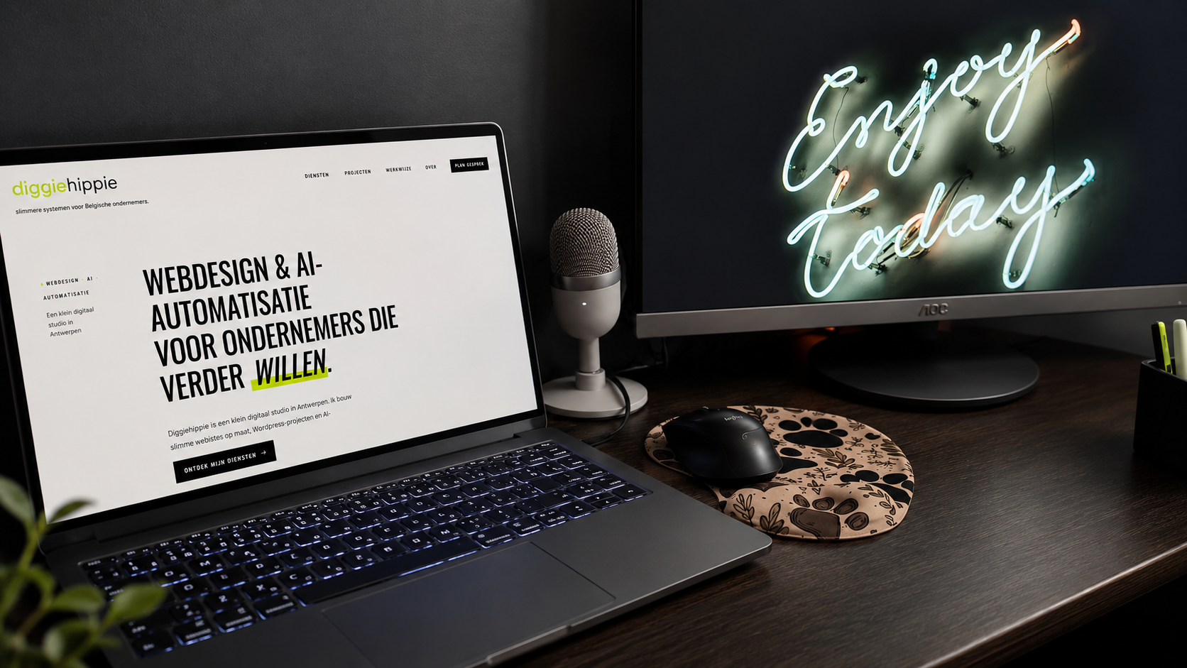 Werkplek van Diggiehippie met laptop, extern scherm en microfoon, waar webdesign, AI-oplossingen en automatiseringen voor Belgische ondernemers worden ontwikkeld.